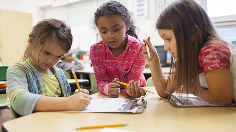 Three first grade female students work on a worksheet at Kae Avenue Elementary classroom, in Columbus, Ohio.