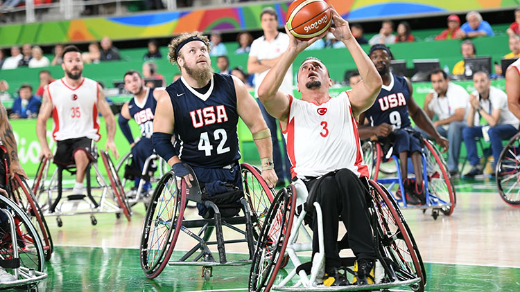 men in wheelchairs play basketball