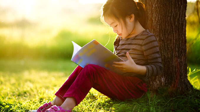 girl reading by a tree