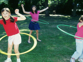 Children spinning toy hoops around their waists