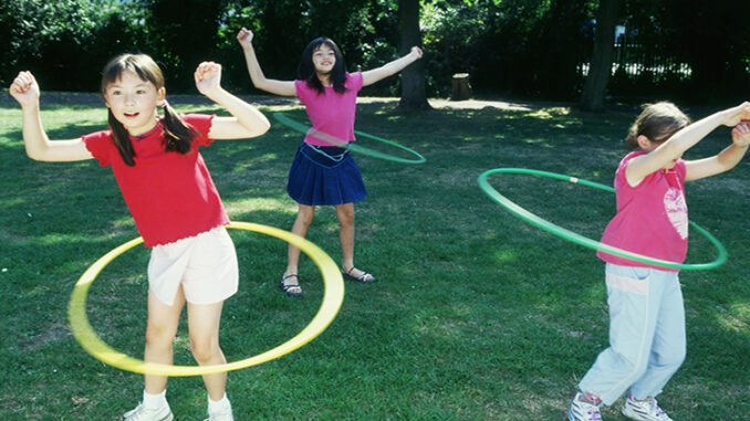 Children spinning toy hoops around their waists