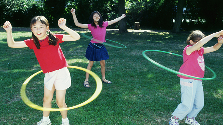 Children spinning toy hoops around their waists