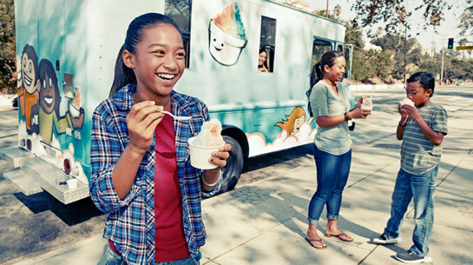 Girl eating ice cream from a truck